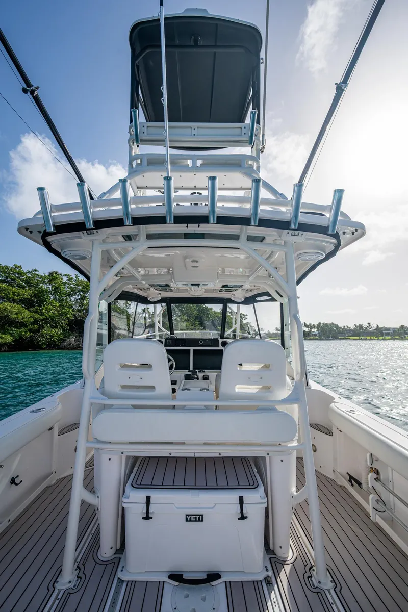 Slide: The Image of 2014 Everglades 350LX boat interior with seating and fishing equipment, on a sunny day. - 16