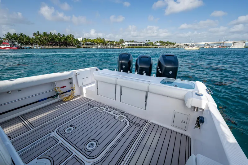 Slide: The Image of 2014 Everglades 350LX boat with triple engines, docked near a scenic waterfront. - 19