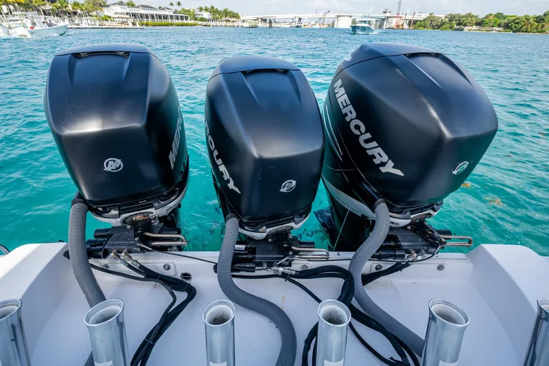 Slide: The Image of Triple Mercury outboard engines on a 2014 Everglades 350LX boat in clear blue water. - 23