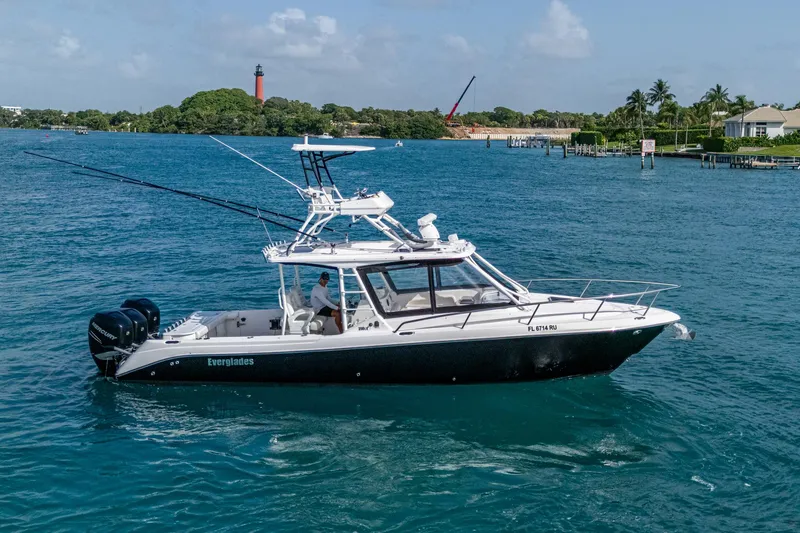 Slide: The Image of 2014 Everglades 350LX boat cruising on blue water near a lighthouse. - 29