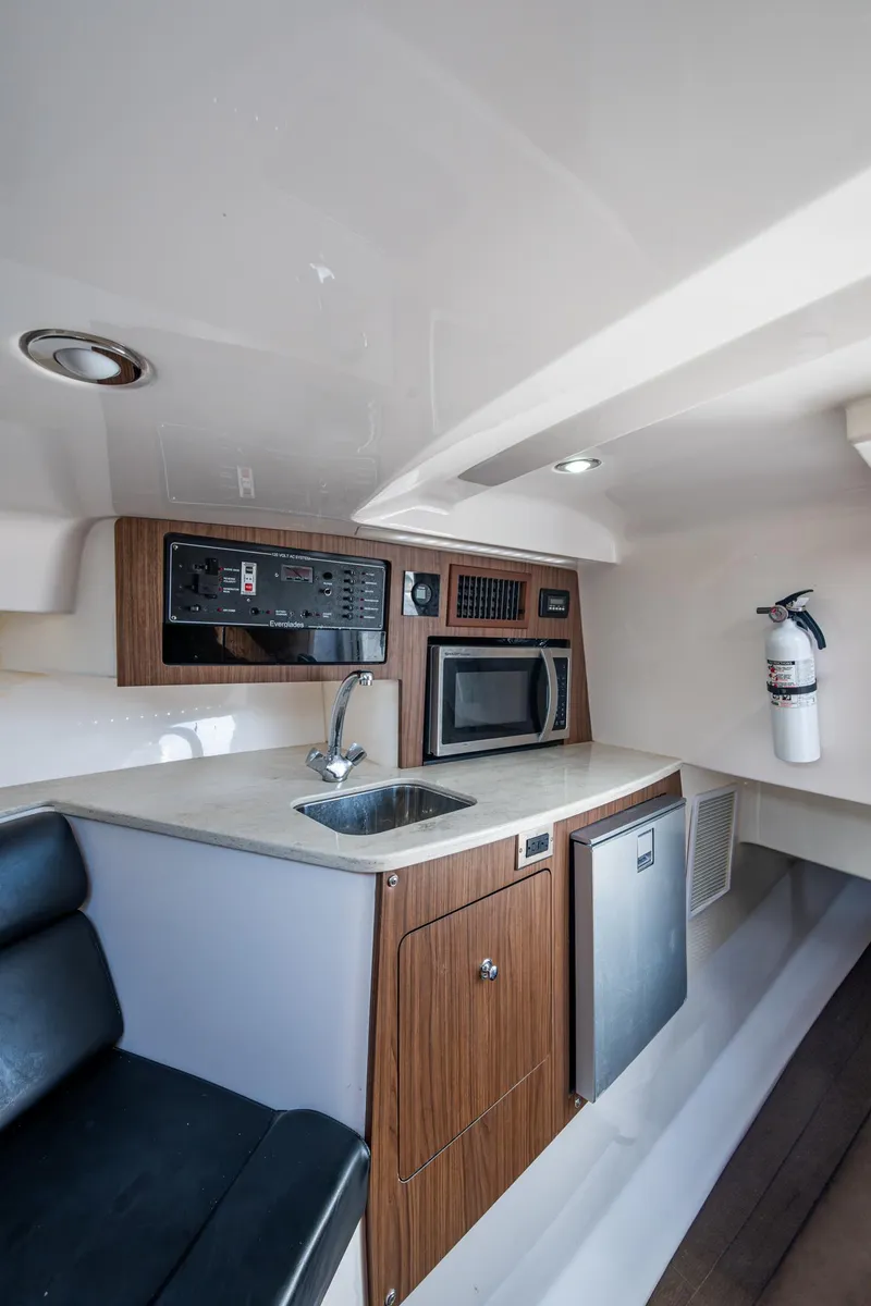 Slide: The Image of 2014 Everglades 350LX cabin interior with kitchenette, sink, microwave, and fire extinguisher. - 6