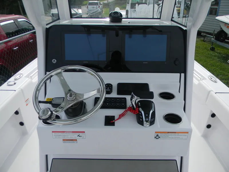 Slide: The Image of 2025 Sportsman Masters 247OE Bay Boat helm with dual screens and steering wheel. - 23