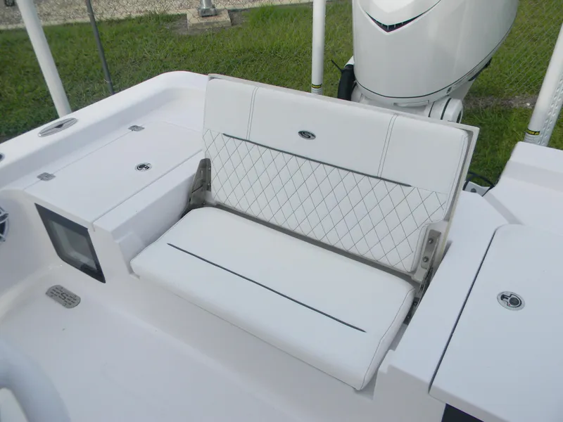 Slide: The Image of 2025 Sportsman Masters 247OE Bay Boat with white cushioned seating and storage compartments. - 25