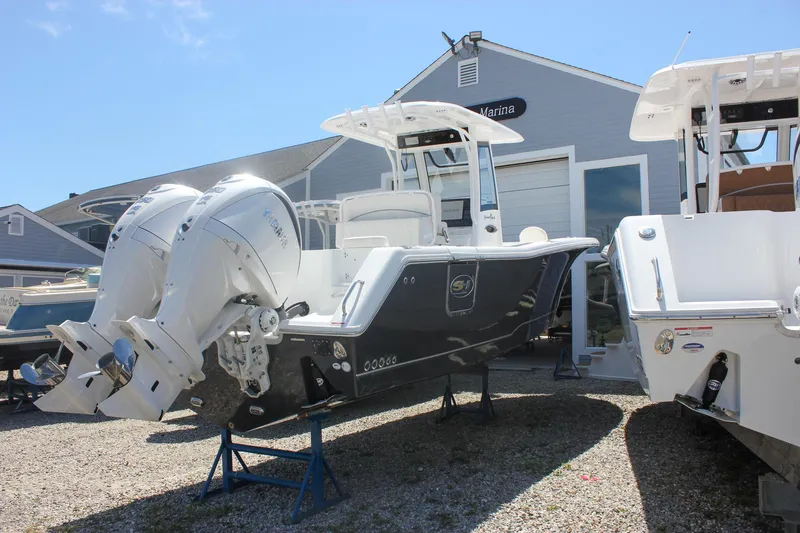 Slide: The Image of 2026 Sea Hunt Gamefish 27 boat with dual Yamaha engines, displayed at a marina. - 5