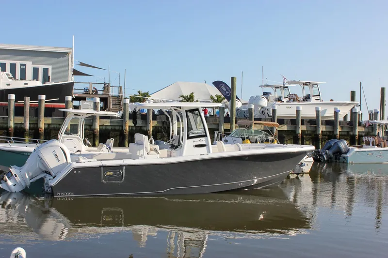 Slide: The Image of 2026 Sea Hunt Gamefish 27 Forward Seating boat docked at marina, clear sky background. - 60