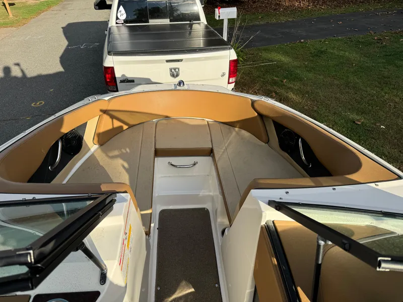 Slide: The Image of 2017 Sea Ray SPX 190 boat interior with tan seating, parked near a white truck. - 4