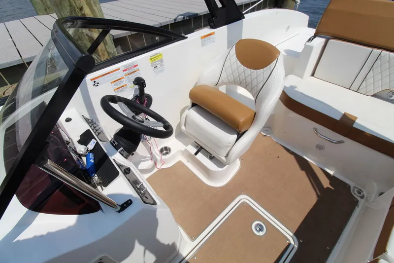 Slide: The Image of 2022 Bayliner DX2000 boat interior with steering wheel and seating. - 12