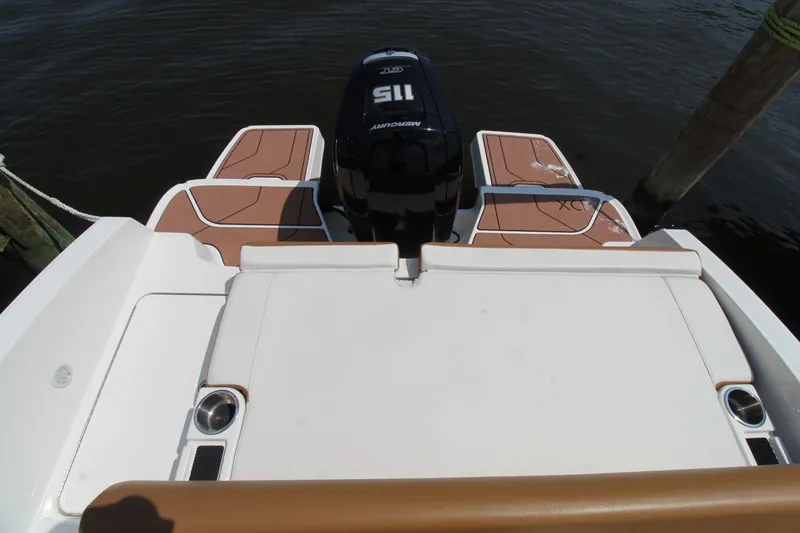 Slide: The Image of 2022 Bayliner DX2000 boat with Mercury 115 outboard motor, docked on calm water. - 14