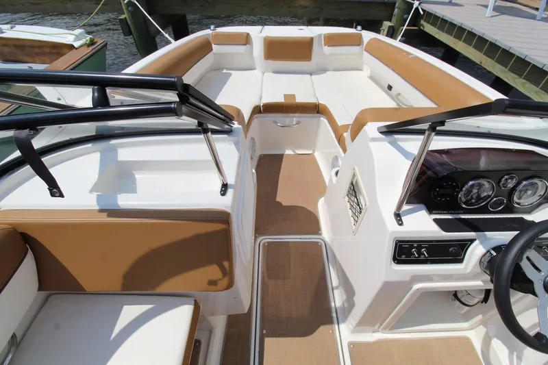 Slide: The Image of 2022 Bayliner DX2000 boat interior with tan and white seating, dashboard, and steering wheel. - 21