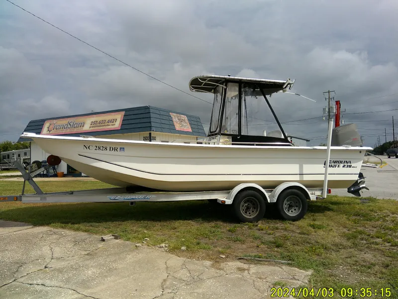 The Image of 2010 Carolina Skiff 238 DLV boat on trailer, parked outdoors. - 1