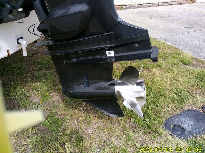 Slide: The Image of Outboard motor of a 2010 Carolina Skiff 238 DLV on grass. - 22