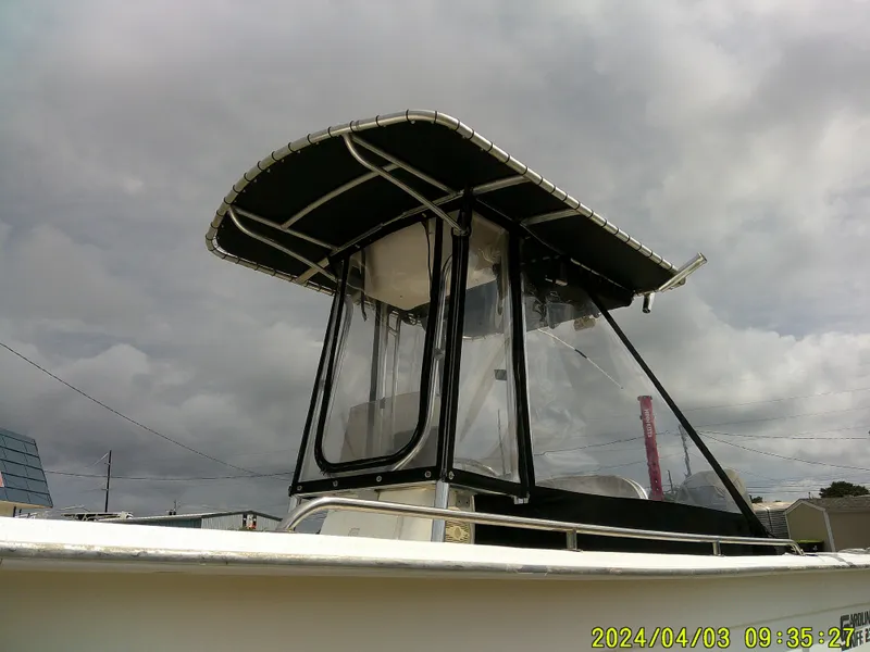 Slide: The Image of 2010 Carolina Skiff 238 DLV boat with canopy under cloudy sky. - 3