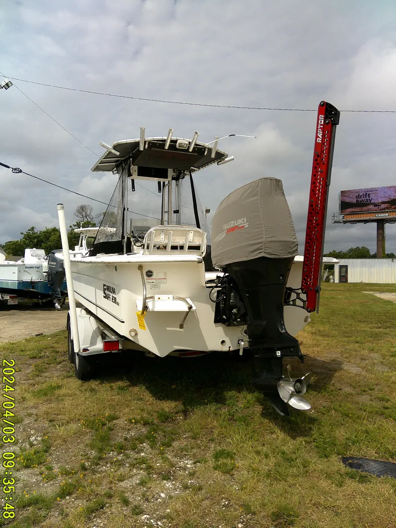 Slide: The Image of 2010 Carolina Skiff 238 DLV boat with Suzuki outboard motor on grassy lot. - 5