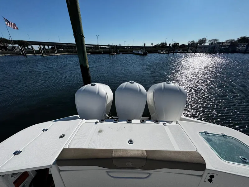 Slide: The Image of 2020 Edgewater 370CC boat with triple engines on a sunny waterfront. - 10
