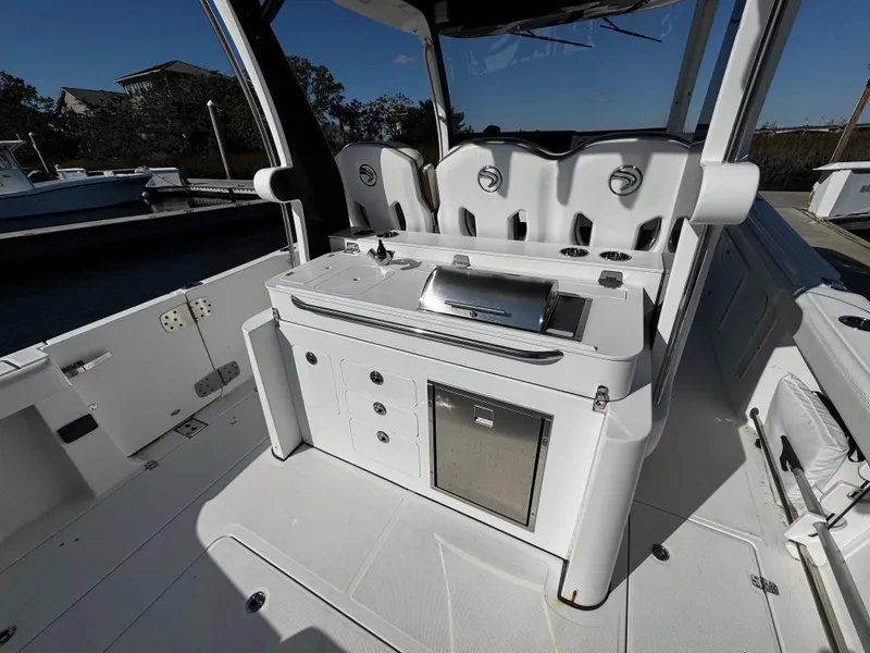 Slide: The Image of 2020 Edgewater 370CC boat interior with seating and built-in grill station. - 13