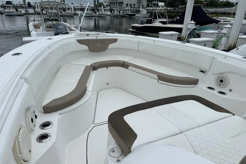 Slide: The Image of 2020 Edgewater 370CC boat with spacious seating at a marina. - 6