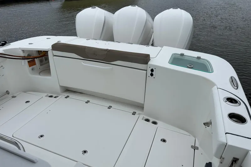 Slide: The Image of 2020 Edgewater 370CC boat deck with storage and triple outboard engines. - 8