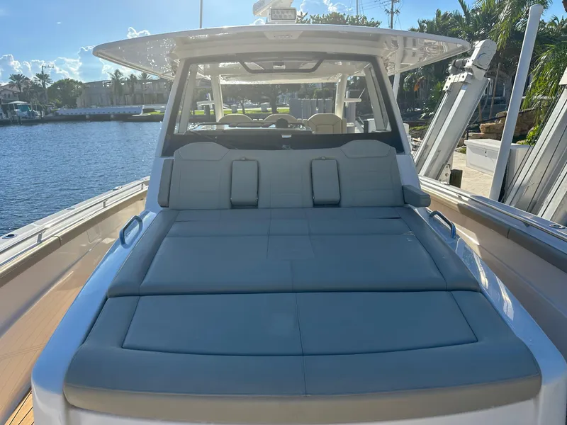 Slide: The Image of 2018 Pursuit 408S boat with spacious deck, docked by a serene waterfront. - 10