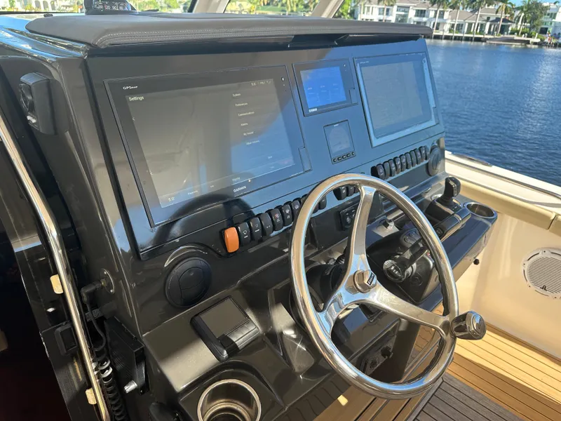 Slide: The Image of Helm of 2018 Pursuit 408S boat with dual navigation screens and steering wheel. - 12