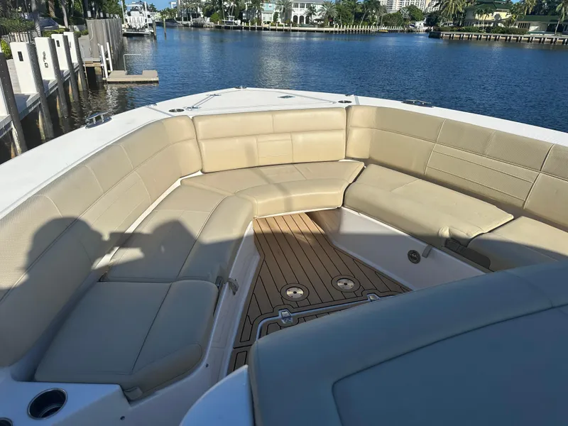 Slide: The Image of 2018 Pursuit 408S boat with spacious seating, docked by a scenic waterfront. - 14