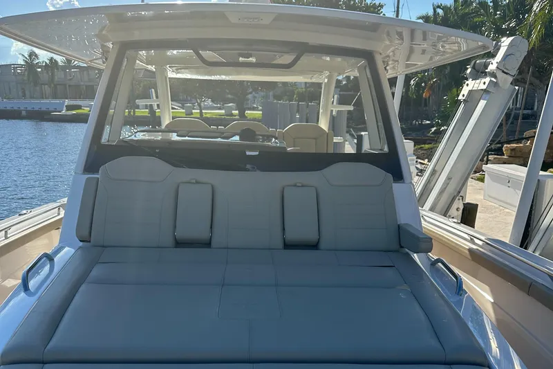 Slide: The Image of 2018 Pursuit 408S boat with spacious seating, docked by the water. - 15