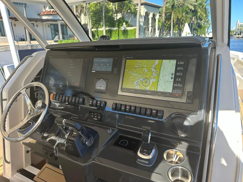Slide: The Image of 2018 Pursuit 408S boat dashboard with navigation system and controls. - 2