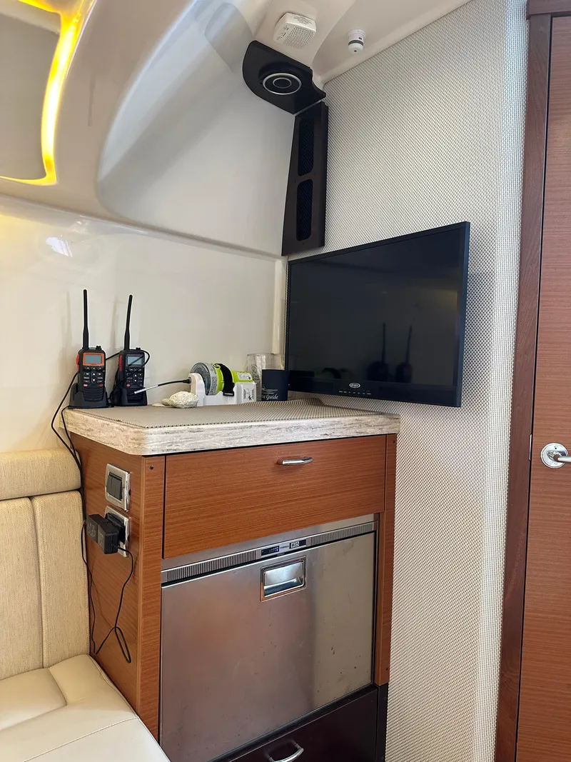 Slide: The Image of Interior of 2018 Pursuit 408S boat with TV, radio, and mini fridge. - 22
