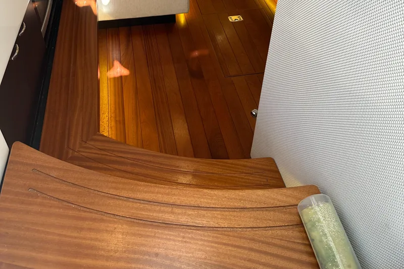 Slide: The Image of Interior of a 2018 Pursuit 408S boat with wooden flooring and seating. - 24