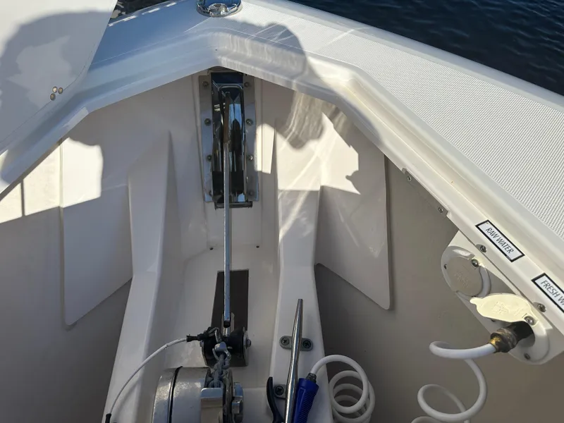Slide: The Image of 2018 Pursuit 408S boat anchor compartment with winch and coiled hose. - 26