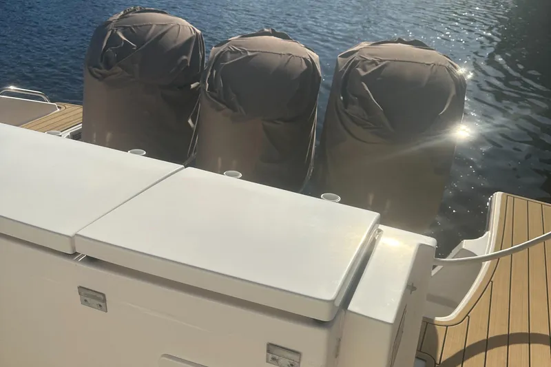 Slide: The Image of 2018 Pursuit 408S boat with triple covered engines on water. - 28