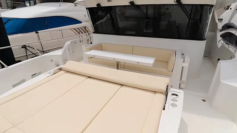 Slide: The Image of Luxurious Selene 64 yacht deck with beige seating, table, and modern design, 2027 model. - 11