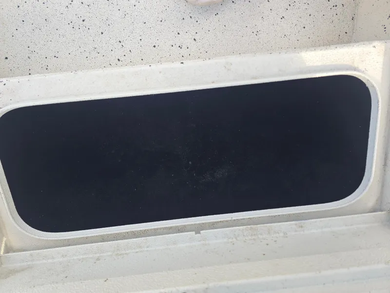 Slide: The Image of Open storage compartment on a 2020 Xpress H20B boat, featuring a dark interior. - 20