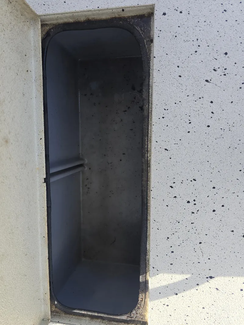 Slide: The Image of Open compartment in 2020 Xpress H20B boat, showing interior details and speckled exterior surface. - 23