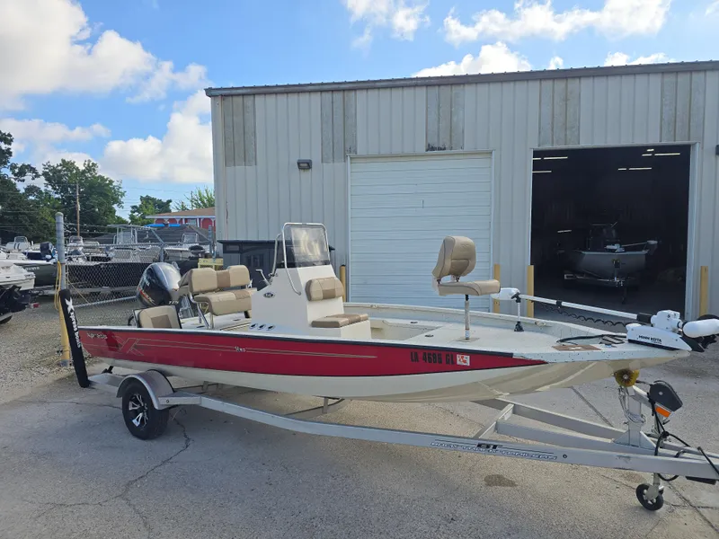 Slide: The Image of 2020 Xpress H20B boat on trailer, parked outside a warehouse under a partly cloudy sky. - 4