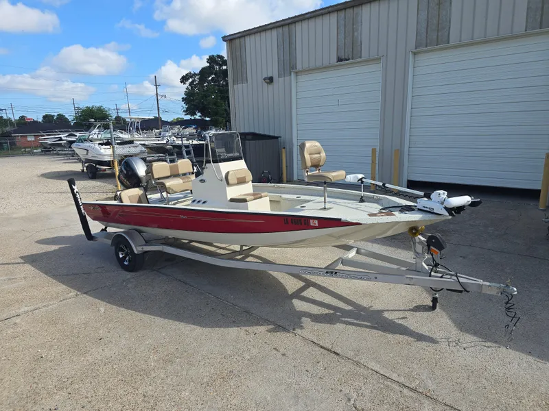 Slide: The Image of 2020 Xpress H20B boat with red hull on trailer, parked outside a warehouse. - 6