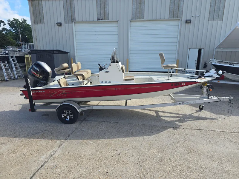 Slide: The Image of 2020 Xpress H20B boat with trailer, red and white, parked outside a warehouse. - 7
