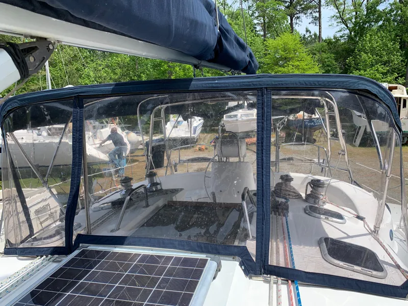 Slide: The Image of 2002 Hunter 410 sailboat with cockpit enclosure and solar panel, docked in a marina. - 17