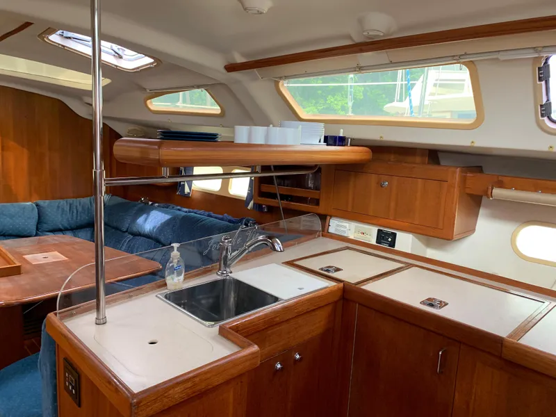 Slide: The Image of Interior of 2002 Hunter 410 yacht with wooden cabinetry and blue seating. - 20