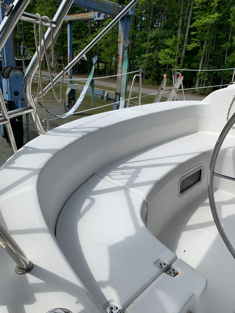 Slide: The Image of 2002 Hunter 410 sailboat cockpit with white seating and metal railings. - 21