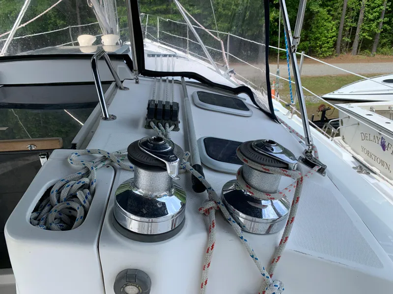 Slide: The Image of Deck of 2002 Hunter 410 sailboat with winches and ropes, docked near trees. - 22