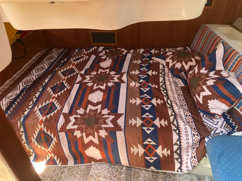 Slide: The Image of Cozy bed with Southwestern-patterned quilt in 2002 Hunter 410 boat cabin. - 28
