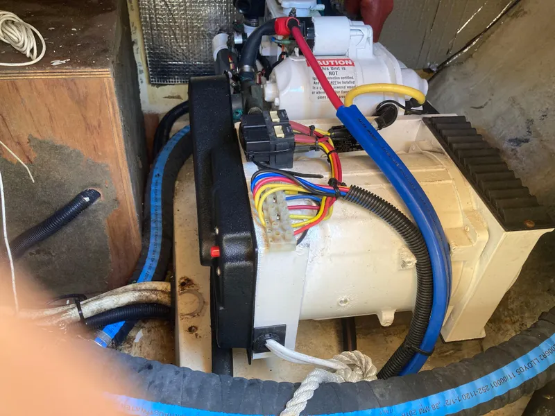 Slide: The Image of Engine compartment of a 2002 Hunter 410 sailboat with visible wiring and components. - 29