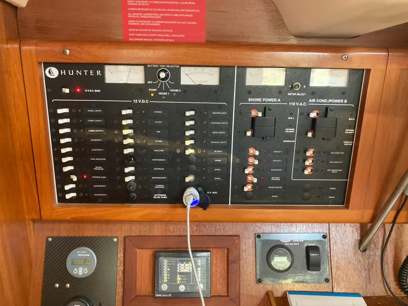 Slide: The Image of Electrical control panel on a 2002 Hunter 410 boat, featuring various switches and gauges. - 30