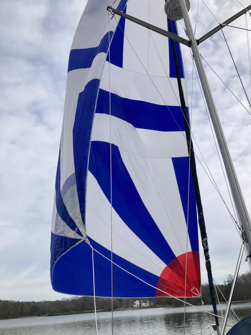 Slide: The Image of Sailboat with blue and white spinnaker sail on a calm lake, Hunter 410, 2002 model. - 34