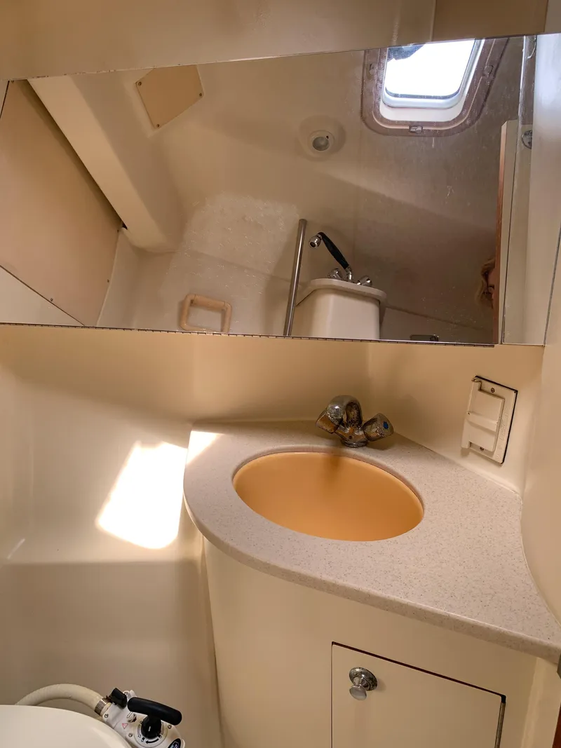 Slide: The Image of Compact bathroom in a 2002 Hunter 410 yacht with sink, mirror, and porthole. - 6