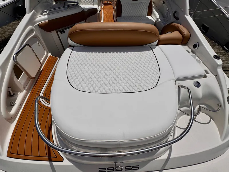 Slide: The Image of 2005 Monterey 298SS Super Sport boat interior with white and tan seating, teak flooring. - 10
