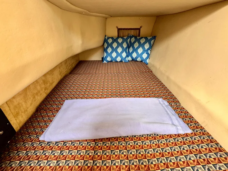 Slide: The Image of Cozy cabin interior of 2005 Monterey 298SS Super Sport with patterned bedding and blue pillows. - 16