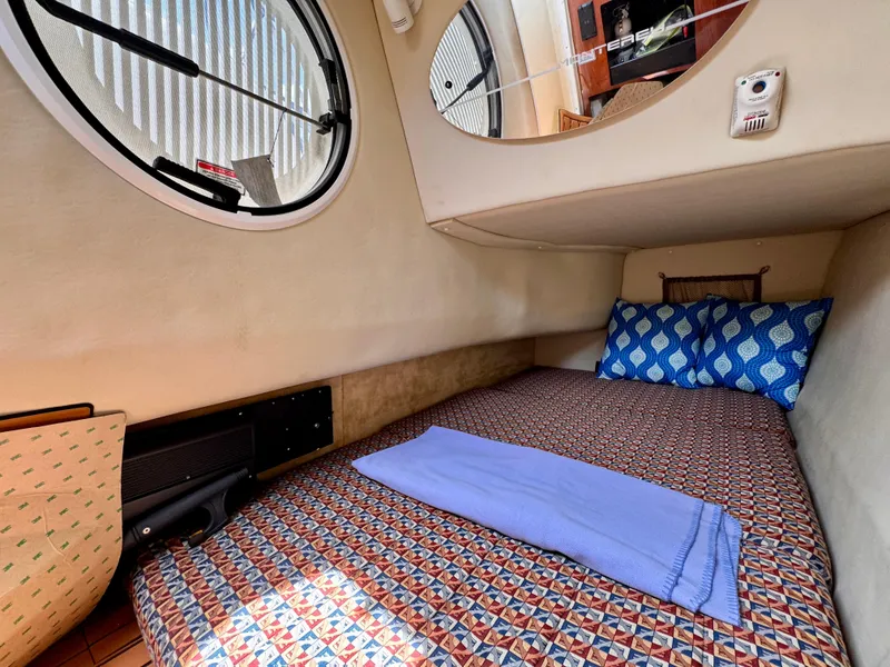 Slide: The Image of Cozy cabin interior of 2005 Monterey 298SS Super Sport with patterned bedding and porthole window. - 17