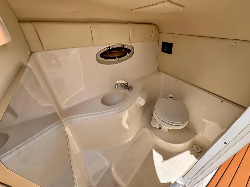 Slide: The Image of 2005 Monterey 298SS Super Sport boat bathroom with sink, toilet, and porthole window. - 18
