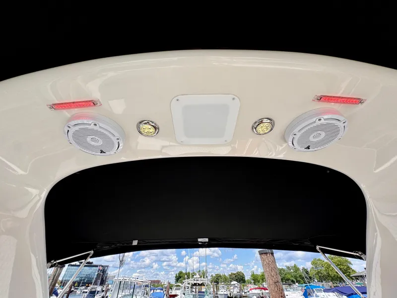 Slide: The Image of 2005 Monterey 298SS Super Sport boat speakers and lights under canopy, marina view. - 20